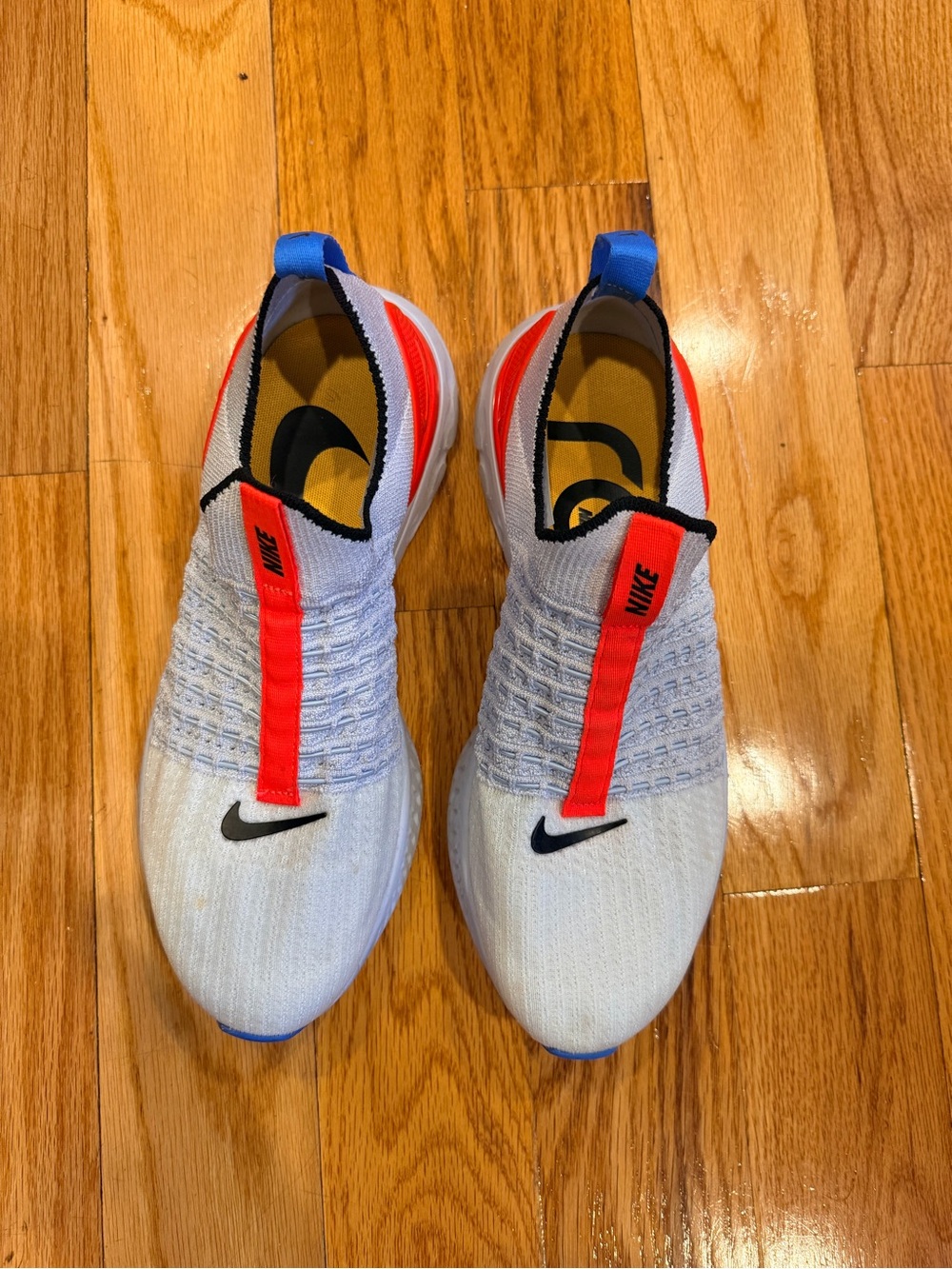 Nike White Slip-On Flyknit Sneakers with Red & Blue Accents